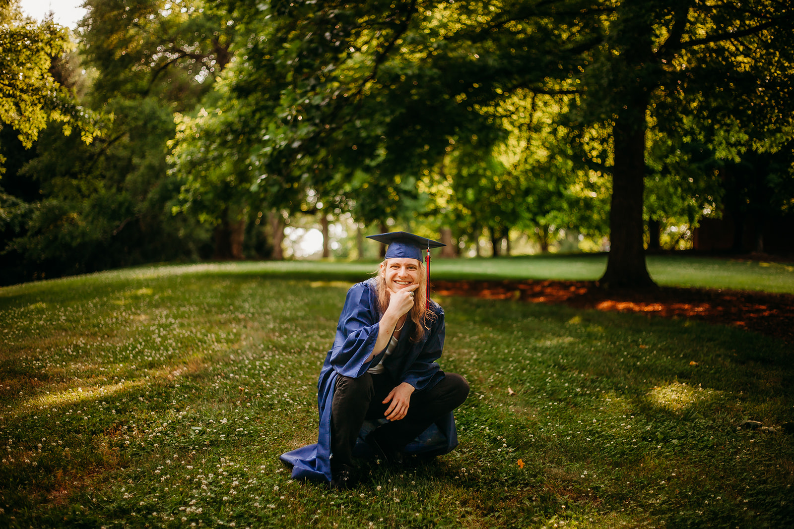 senior posing for his high school cap n gown