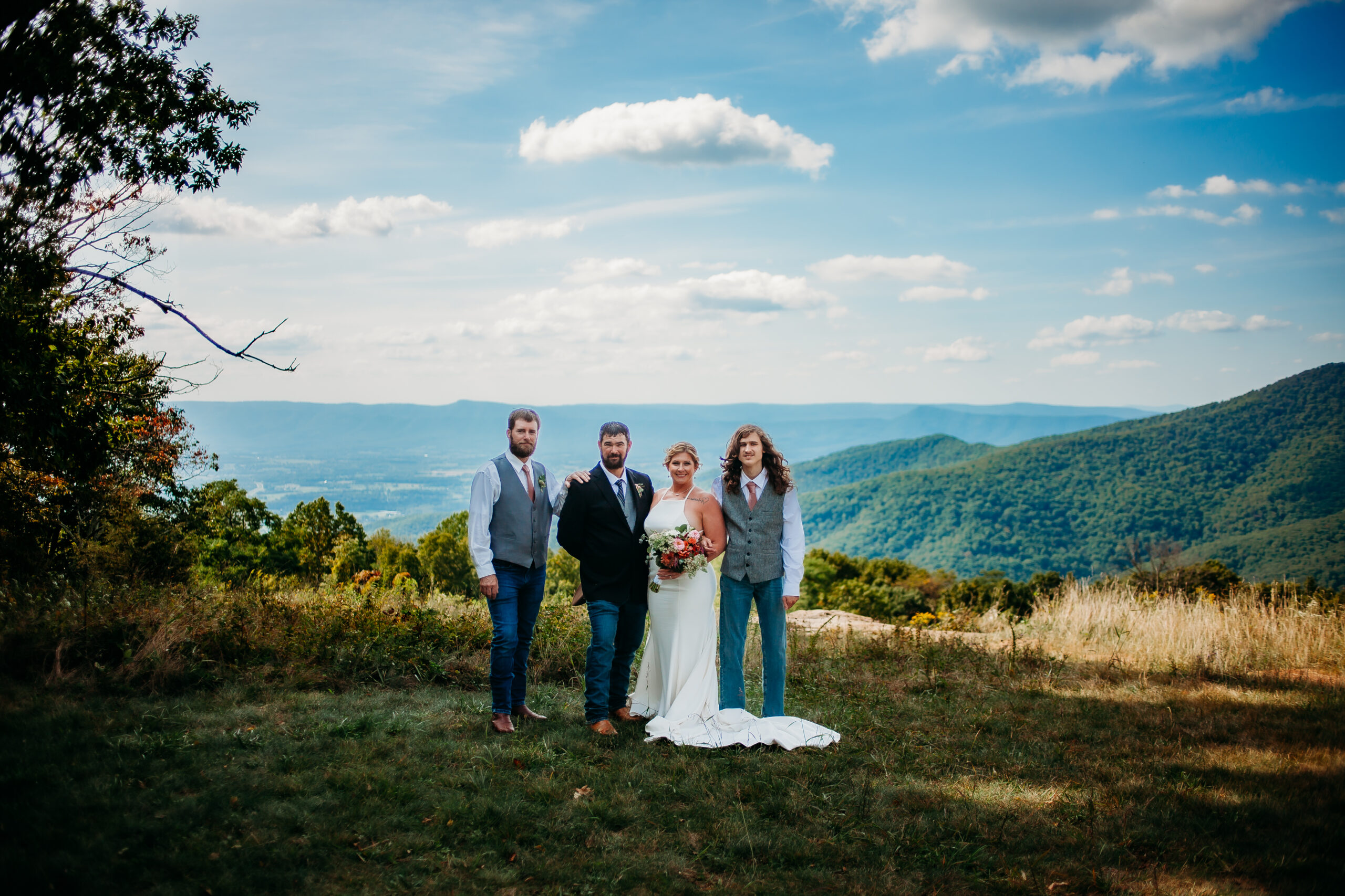 a couple standing on a rocky overlook during their virginia hiking elopement, with breathtaking mountain views in the background.